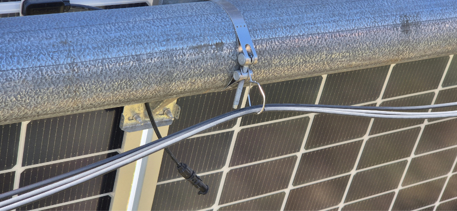 ECLIPZ Cable Harness Hanger installed on Nextracker torque tube with string cables secured at utility-scale solar farm